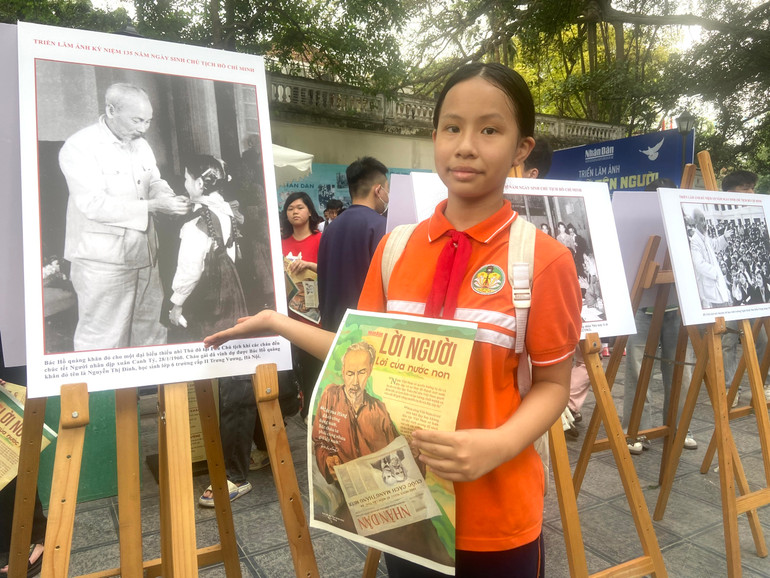 Phạm Phương Anh bên bức ảnh Chủ tịch Hồ Chí Minh đeo khăn quàng đỏ cho bà Nguyễn Thị Định.