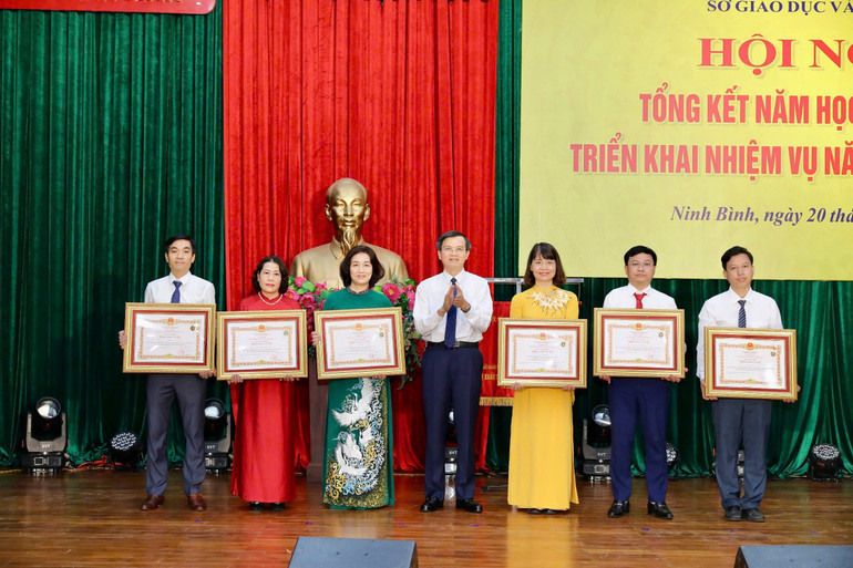 Thừa ủy quyền của Chủ tịch nước, Bí thư Tỉnh ủy Ninh Bình Đoàn Minh Huấn trao tặng Bằng công nhận Nhà giáo Ưu tú của Chủ tịch nước cho các thầy, cô giáo. (Ảnh: Minh Quang)