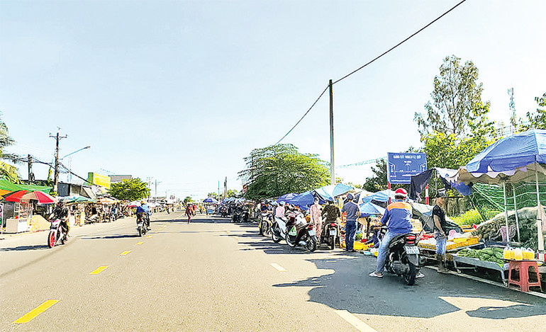 Người dân mua bán lấn chiếm lòng đường trên Quốc lộ 61C thuộc phường Tân Xuyên, thành phố Cà Mau.