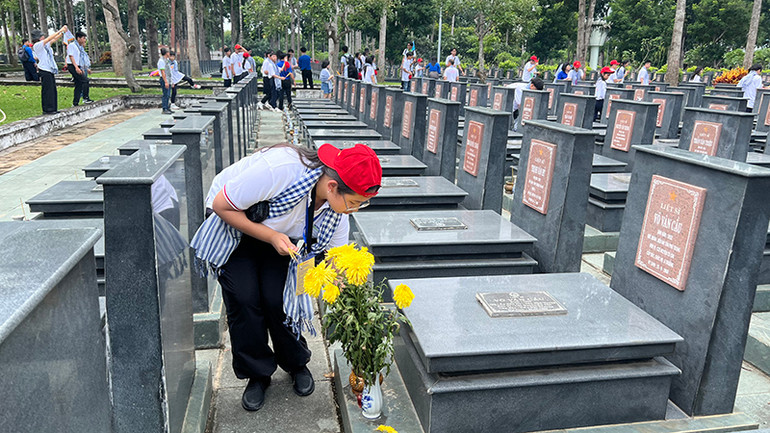 Các trại sinh thắp hương mộ liệt sĩ tại Nghĩa trang Liệt sĩ huyện Củ Chi.