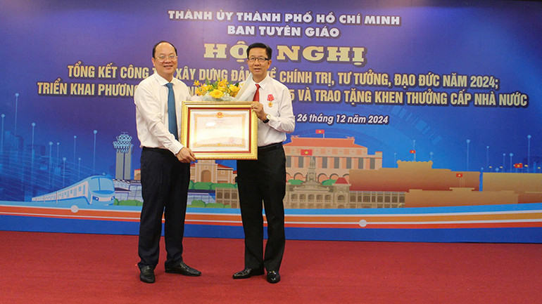 Đồng chí Nguyễn Hồ Hải (trái), Phó Bí thư Thường trực Thành ủy Thành phố Hồ Chí Minh trao Huân chương Lao động hạng Nhất của Chủ tịch nước cho đồng chí Phạm Đức Hải, nguyên Phó Trưởng Ban Tuyên giáo Thành ủy Thành phố Hồ Chí Minh.
