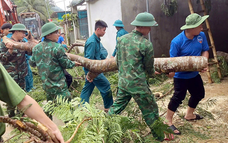 Lực lượng chức năng huyện Mường Lát (Thanh Hóa) sơ tán người dân ở xã Pù Nhi và thị trấn Mường Lát khỏi các nhà bị tốc mái, đồng thời giúp người dân khắc phục nhà bị hư hỏng. (Ảnh LÊ DƯƠNG)