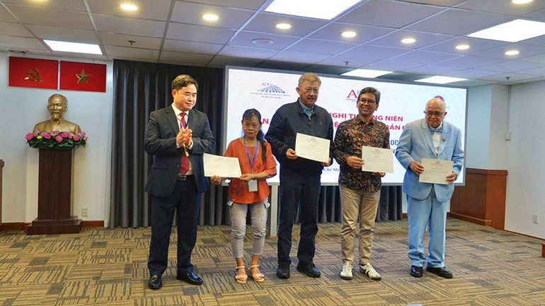 Chủ tịch Hội Xuất bản Việt Nam Phạm Minh Tuấn tặng Giấy chứng nhận cho một số thành viên kỳ cựu.