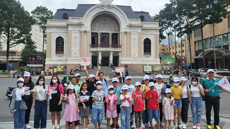 Các em thiếu nhi chụp ảnh lưu niệm trước Nhà hát Thành phố.