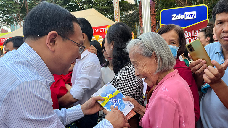 Ông Lâm Đình Thắng, Giám đốc Sở Thông tin và Truyền thông Thành phố Hồ Chí Minh lì xì sách Tết cho du khách.