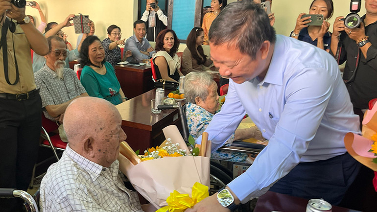 Phó Chủ tịch Ủy ban nhân dân Thành phố Hồ Chí Minh Dương Anh Đức tặng hoa cho nghệ sĩ Mạc Can.