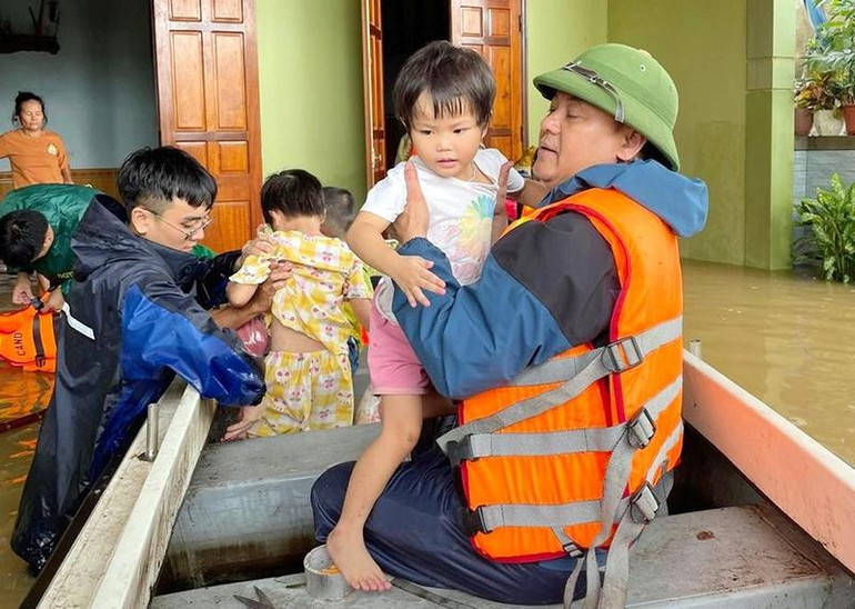 Lực lượng chức năng xã Lăng Thành, huyện Yên Thành, tỉnh Nghệ An sơ tán người dân khi nước lũ dâng cao. (Ảnh VĂN TRƯỜNG)