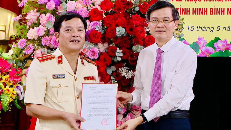 Bí thư Tỉnh ủy Ninh Bình Đoàn Minh Huấn trao quyết định và tặng hoa chúc mừng đồng chí Phạm Ngọc Cảnh, Bí thư Ban cán sự đảng Viện Kiểm sát nhân dân tỉnh Ninh Bình.