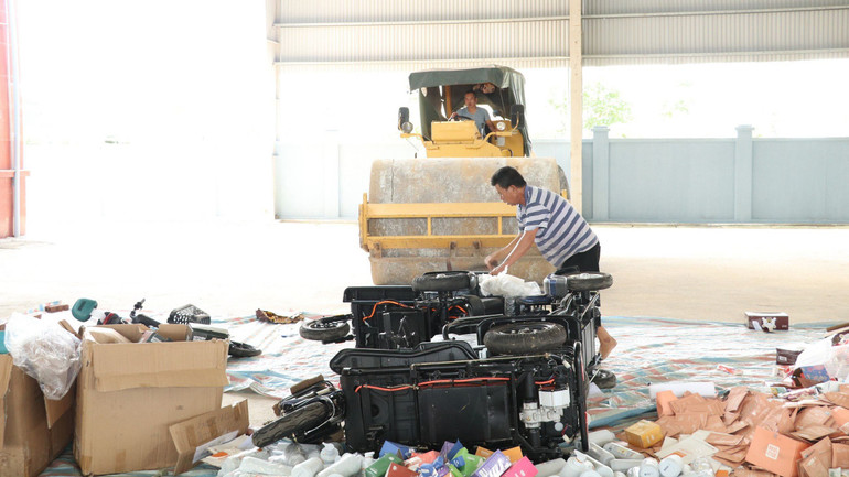 Các loại hàng hóa vi phạm được tiêu hủy bằng cách dùng xe lu nghiền nát đến khi không còn giá trị sử dụng.