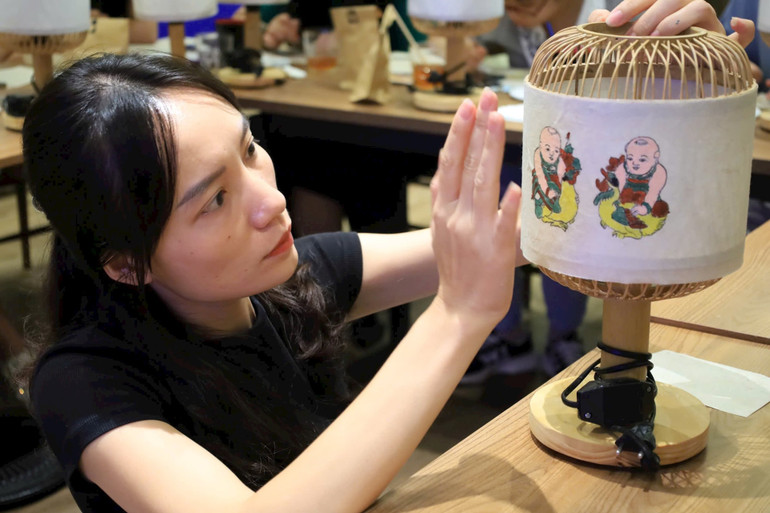 Tranh dân gian Đông Hồ được ứng dụng vào sản xuất sản phẩm đèn bàn. (Ảnh Dự án "Màu dân tộc".