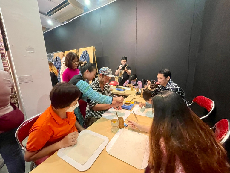 Công chúng tham gia trải nghiệm vẽ hoa văn sáp ong truyền thống.
