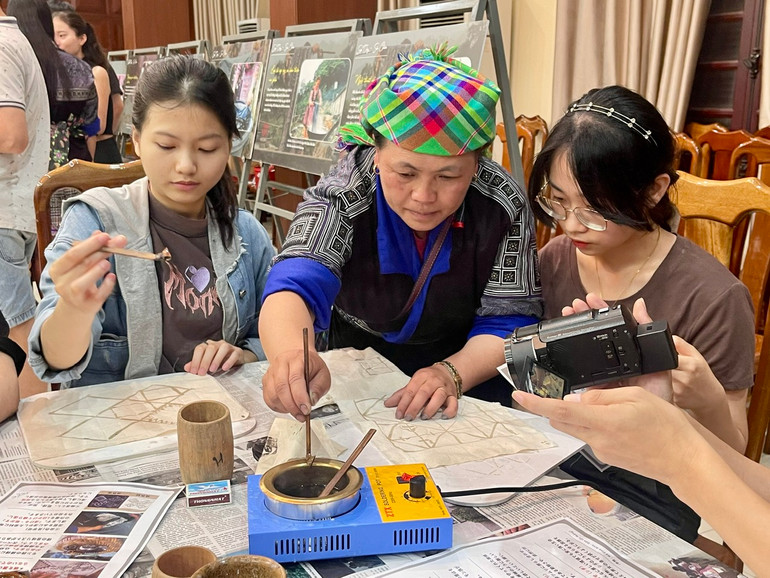 Nghệ nhân người Mông hướng dẫn kỹ thuật vẽ sáp ong. Nghệ nhân người Mông hướng dẫn kỹ thuật vẽ sáp ong.