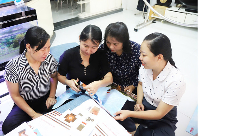 Bạn đọc tỉnh Ninh Thuận thực hiện việc cắt ghép tranh "Cột cờ Hà Nội" từ ấn phẩm đặc biệt do Báo Nhân Dân trao tặng. (Ảnh: NGUYỄN TRUNG)