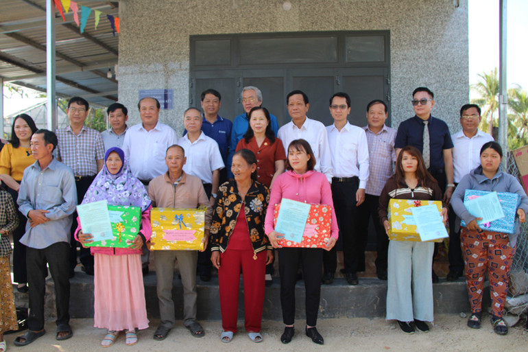 Lãnh đạo địa phương chụp ảnh lưu niệm với bà con tại lễ bàn giao nhà 'Đại đoàn kết". (Ảnh: NGUYỄN TRUNG)