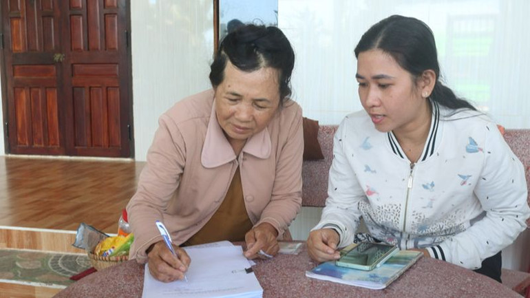 Cán bộ xã Phước Dinh, huyện Thuận Nam (Ninh Thuận) hướng dẫn người dân ký cam kết giữ nguyên hiện trạng đất đai và tài sản gắn liền với đất.