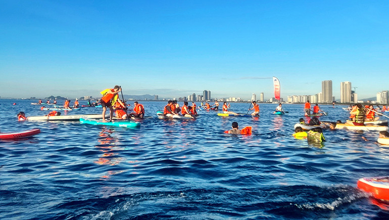 Người chơi SUP bơi lội, thư giãn trên biển.