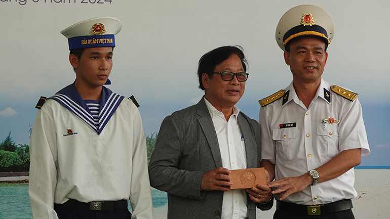 Thượng tá Hà Văn Hậu (bìa phải), Phó Chính ủy Lữ đoàn 125 Hải quân tặng cho Đường sách thành phố Thủ Đức viên gạch Trường Sa.