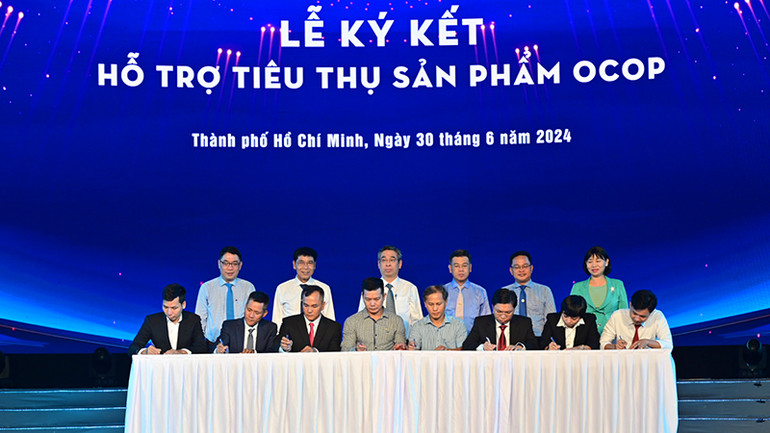 Các đơn vị thực hiện lễ ký kết hỗ trợ tiêu thụ sản phẩm OCOP tại chương trình. (Ảnh: Quốc Thanh)