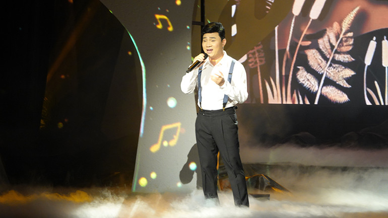 Ca sĩ Quang Linh mở đầu chương trình bằng ca khúc "Xin làm người hát rong".