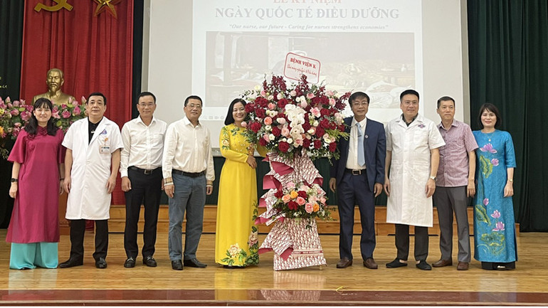 Lãnh đạo Bệnh viện K trao tặng lẵng hoa cho đại diện điều dưỡng, kỹ thuật viên tại Lễ kỷ niệm.