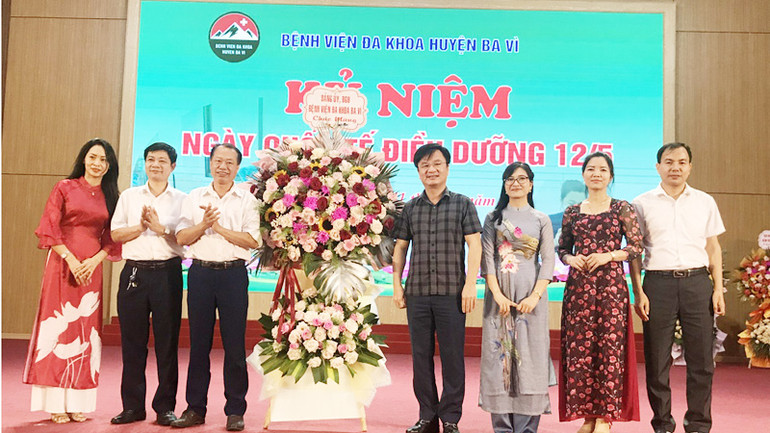 Lãnh đạo Bệnh viện Đa khoa huyện Ba Vì trao tặng lẵng hoa cho các điều dưỡng công tác tại đơn vị.