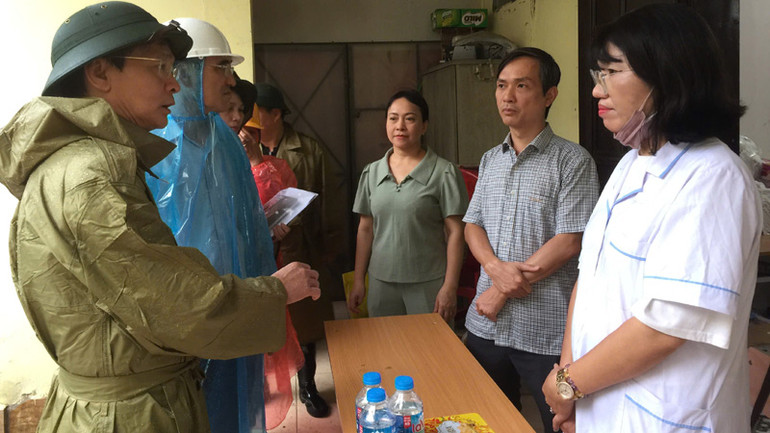 Phó Giám đốc Sở Y tế Vũ Cao Cương trao đổi với các bộ y tế ứng trực chăm sóc sức khỏe cho người dân trên địa bàn quận Ba Đình, thành phố Hà Nội.