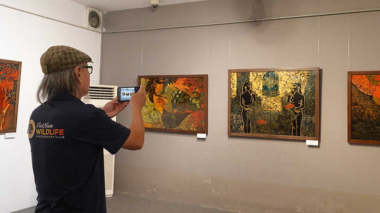 Khán giả xem tranh của nhóm Tam giác mạch tại buổi khai mạc.