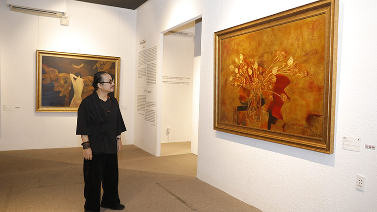 Nghệ sĩ Saxophone Trần Mạnh Tuấn tham quan triển lãm. (Ảnh BTC)