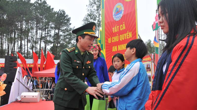 Đại diện lãnh đạo Bộ tư lệnh bộ đội biên phòng trao quà tặng các em học sinh trong Chương trình "Nâng bước em tới trường - Con nuôi đồn biên phòng".