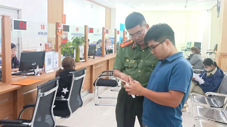 Cán bộ Công an tỉnh hướng dẫn người dân thực hiện thủ tục đề nghị cấp phiếu lý lịch tư pháp qua ứng dụng VNeID trên điện thoại di động.