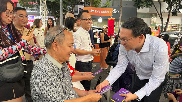 Giám đốc Sở Thông tin và Truyền thông Thành phố Hồ Chí Minh Lâm Đình Thắng lì xì sách cho khách tham dự chương trình.