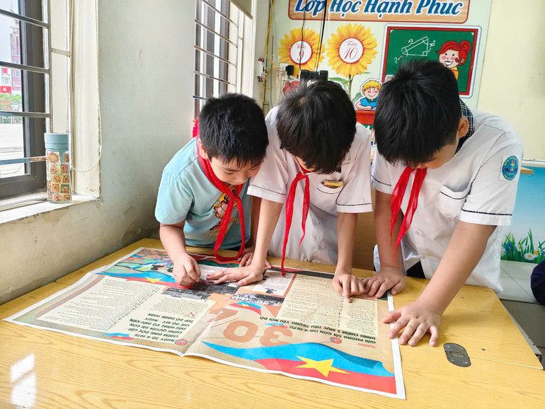 Các bạn nhỏ chăm chú tìm hiểu lịch sử qua những trang Báo in màu đặc sắc. Các bạn nhỏ chăm chú tìm hiểu lịch sử qua những trang Báo in màu đặc sắc.