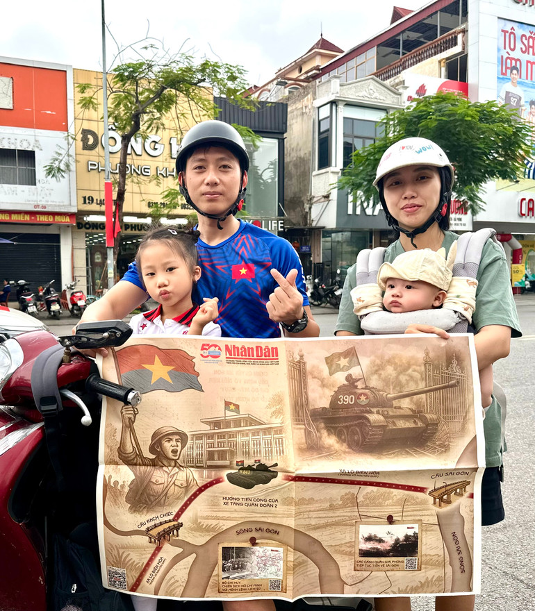 Cả gia đình hào hứng với tờ báo Nhân Dân đặc biệt trong sáng ngày 30/4. (Ảnh: Nguyễn Đức Nghĩa)