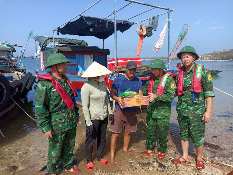 Cán bộ, chiến sĩ Đồn Biên Phòng Bạch Long Vĩ kịp thời hỗ trợ, động viên ngư dân nhu yếu phẩm để tiếp tục vươn khơi, bám biển ngay sau bão Yagi. (Ảnh: Sơn Hà)