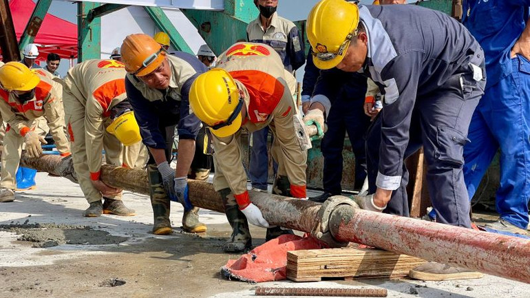 Các công nhân tiếp tục thi công phần khối lượng còn lại của dự án. (Ảnh: YẾN TRINH)