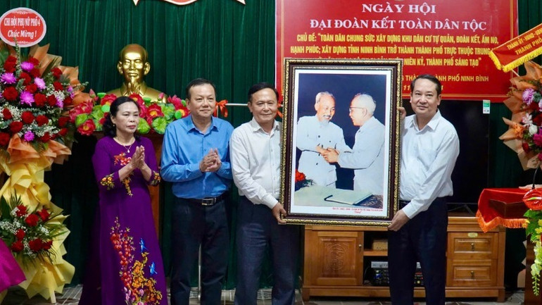 Phó Bí thư Thường trực Tỉnh ủy, Chủ tịch Hội đồng nhân dân tỉnh Ninh Bình Mai Văn Tuất trao tặng bức ảnh "Bác Hồ và Bác Tôn bắt tay đoàn kết" cho đại diện khu phố 4.