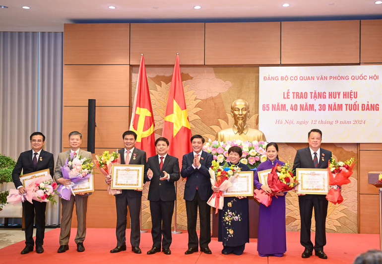 Đồng chí Nguyễn Văn Thể và đồng chí Bùi Văn Cường trao tặng Huy hiệu 30 năm tuổi Đảng cho các đảng viên.