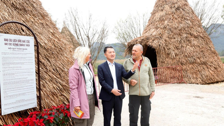 Lãnh đạo Sở Du lịch Ninh Bình chào hỏi, tặng lì xì vợ chồng anh Mojens Randall đến từ Đan Mạch - là những vị khách "xông đất" du lịch Ninh Bình tại Không gian văn hóa Khê Cốc, Khu du lịch Sinh thái Tràng An. (Ảnh: MINH ĐƯỜNG)