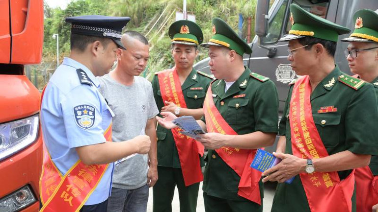 Cán bộ, chiến sĩ Bộ đội Biên phòng Lạng Sơn phối hợp với Trạm kiểm soát biên phòng Quảng Tây (Trung Quốc) tuyên truyền pháp luật cho lái xe chở hàng hóa qua cửa khẩu.