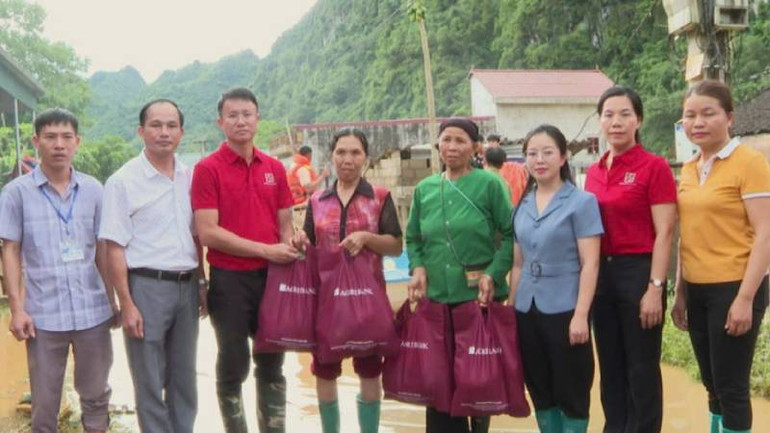 Đại diện công đoàn viên chức Agribank thành phố Lạng Sơn (áo đỏ) trao quà cho các hộ dân bị ảnh hưởng bão số 3 tại thôn Đoàn Kết, xã Tràng Phái, Văn Quan (Lạng Sơn).