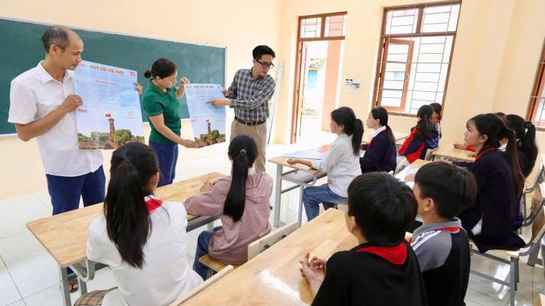 Các thầy, cô giáo trường Trung học cơ sở Tân Văn, huyện Bình Gia (Lạng Sơn) hướng dẫn các em học sinh làm mô hình " Cột cờ Hà Nội".