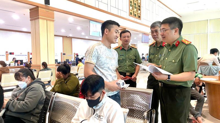 Thượng tá Lương Đức Minh, Phó Giám đốc Công an tỉnh (ngoài cùng bên phải) trao đổi với người dân đến làm thủ tục cấp phiếu Lý lịch tư pháp.