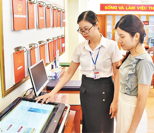 Cán bộ phường Thanh Xuân Nam (quận Thanh Xuân, thành phố Hà Nội) hướng dẫn người dân làm thủ tục hành chính trên môi trường số. (Ảnh: THỦY NGUYÊN)