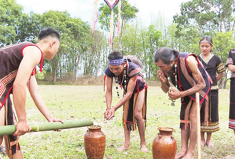 Người dân dùng nước được chủ tế hứng vào ống tre để châm vào ghè rượu và mời già làng thưởng thức.