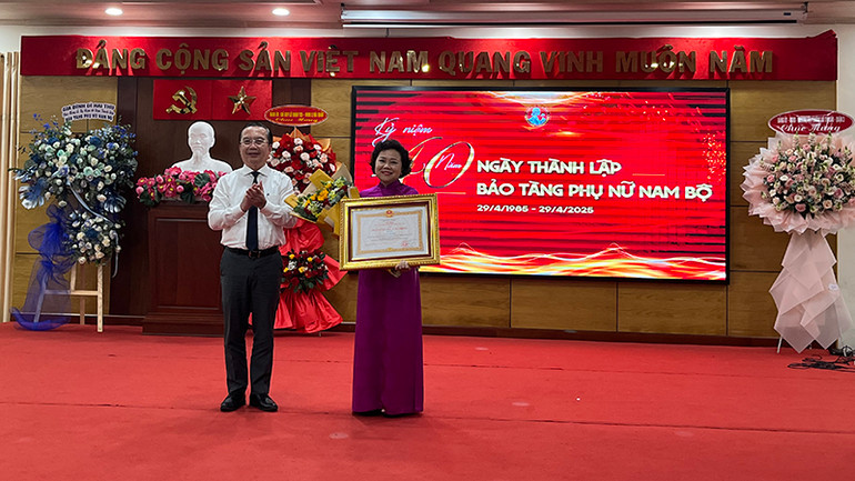 Ông Trần Thế Thuận, Giám đốc Sở Văn hóa và Thể thao Thành phố Hồ Chí Minh trao Huân chương Lao động hạng III cho bà Nguyễn Thị Thắm, nguyên Giám đốc Bảo tàng Phụ nữ Nam Bộ. (Ảnh M.H)