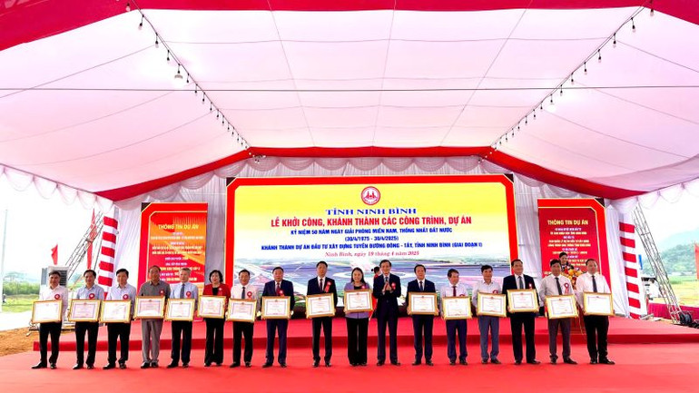 Đồng chí Bí thư Tỉnh ủy Đoàn Minh Huấn trao bằng khen các tập thể và cá nhân có thành tích xuất sắc trong thực hiện dự án. (Ảnh: YẾN TRINH)