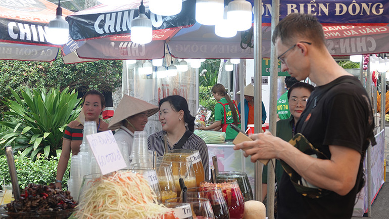 Du khách nước ngoài tìm hiểu ẩm thực Việt tại lễ hội.