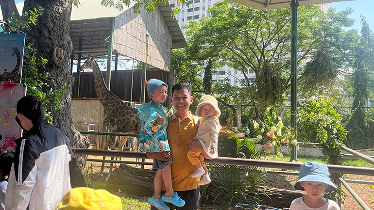 Du khách thích thú chụp ảnh lưu niệm với gia đình hươu cao cổ.