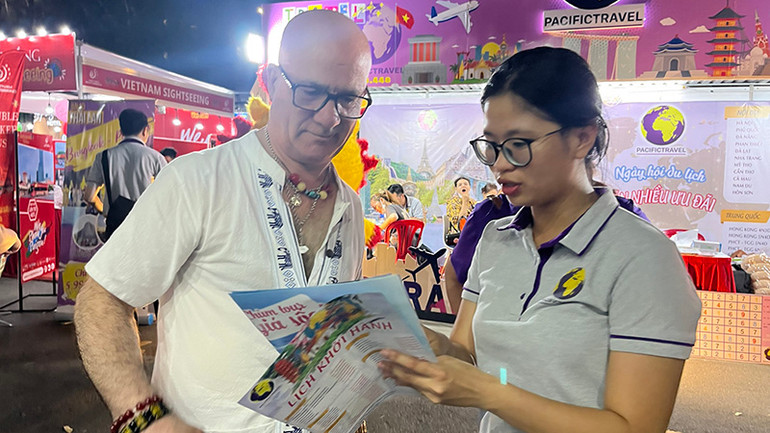 Khách nước ngoài tìm hiểu các tour du lịch trong ngày khai mạc.