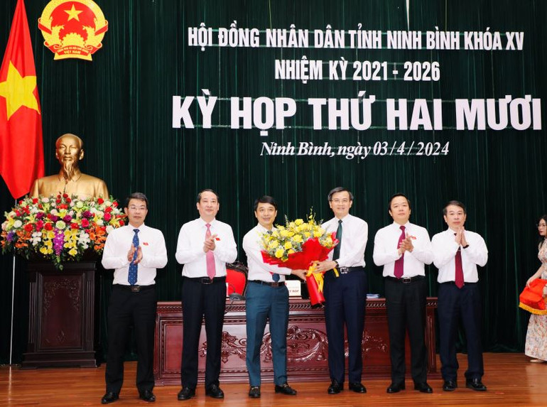Bí thư Tỉnh ủy Đoàn Minh Huấn và các đồng chí lãnh đạo Hội đồng nhân dân, Ủy ban nhân dân tỉnh, Ủy ban Mặt trận Tổ quốc Việt Nam tỉnh đã tặng hoa chúc mừng đồng chí Hoàng Văn Kiên được bầu giữ chức Phó Chủ tịch Hội đồng nhân dân tỉnh Ninh Bình. (Ảnh: ĐỨC LAM)